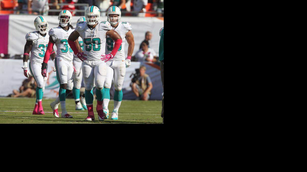 
Miami Dolphins defenders leave the field after giving up a touchdown in the final six seconds of their game to lose to the Green Bay Packers at SunLife Stadium in Miami Gardens on Oct. 12, 2014.
