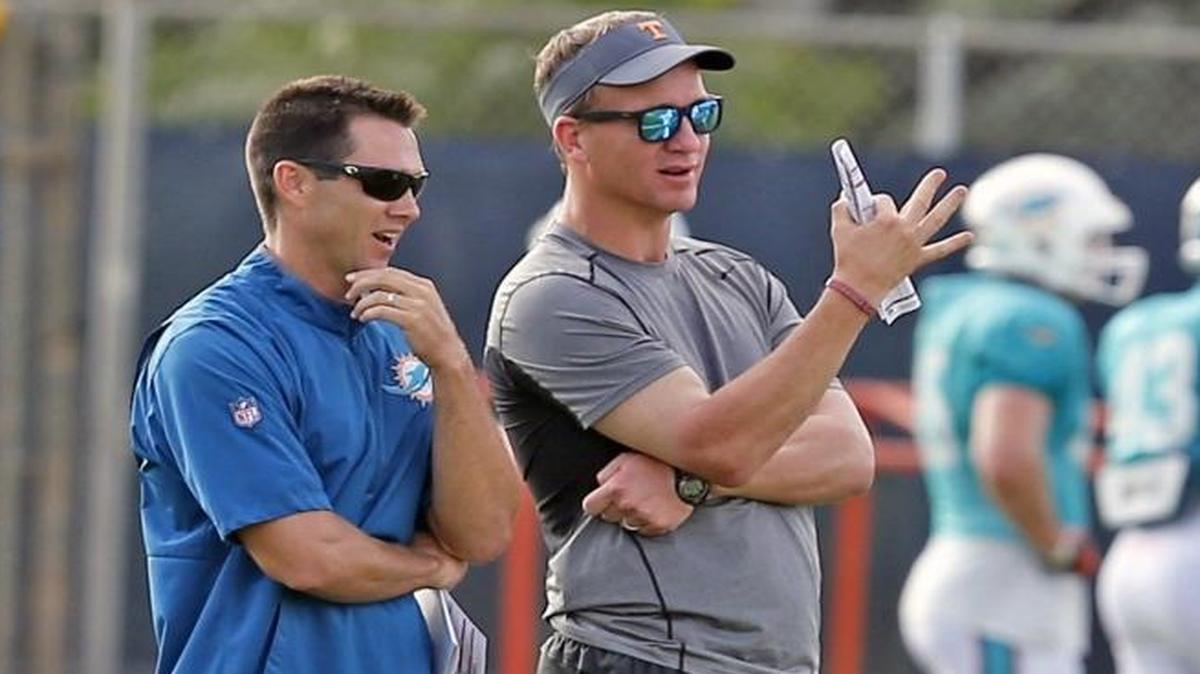 Dolphins director of player personnel Joe Schoen, left, stands with former NFL quarterback Peyton Manning as the Fins practice at the Miami Dolphins training facility in Davie, Florida on Aug. 1, 2016.