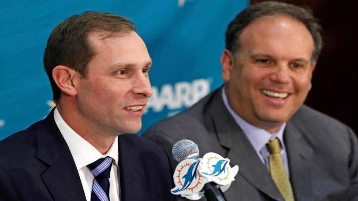 New Miami Dolphins head coach Adam Gase, left, speaks as Mike Tannenbaum, vice president of football operations, listens during an introductory news conference Saturday, Jan. 9, 2016, in Davie, Fla.