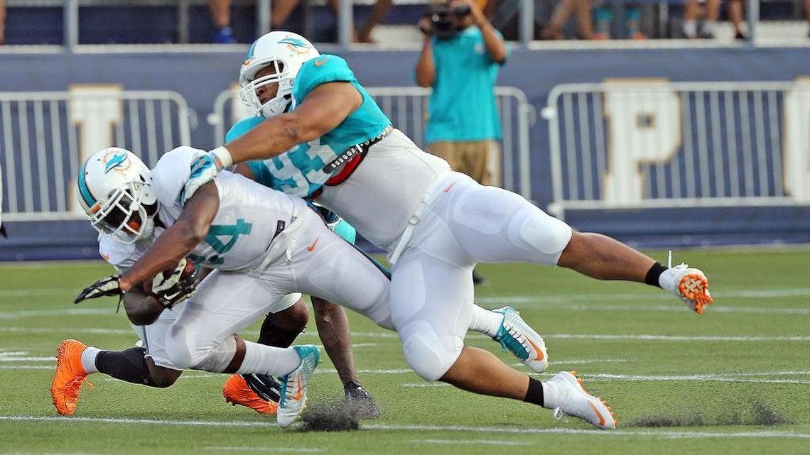 
Ndamukong Suh tackles running back Damien Williams during the Dolphins’ scrimmage Friday, Aug. 7, 2015 at FIU Stadium. 
