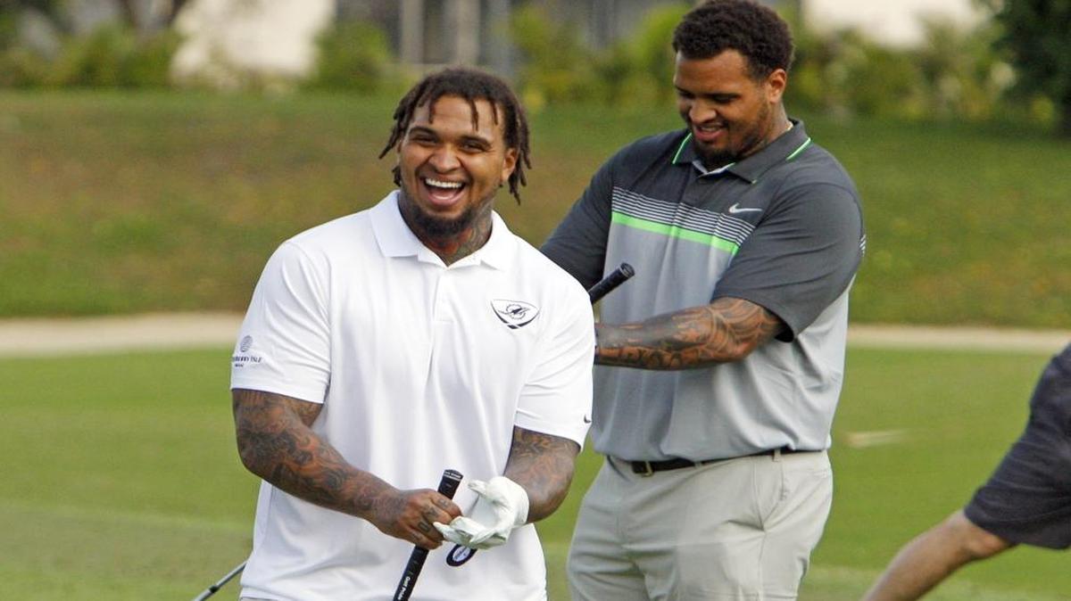 Mike Pouncey, left, shares a laugh with his twin brother, Maurkice, during a Dolphins charity golf event in April. The Pounceys will face each other in football for the first time Sunday when Maurkice and the Steelers are in town.