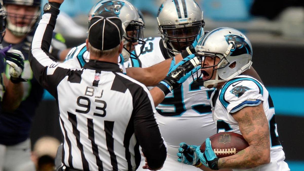 The Panthers’ Cortland Finnegan, right, celebrates after making an interception against the Seahawks during the second quarter in the divisional game at Bank of America Stadium.