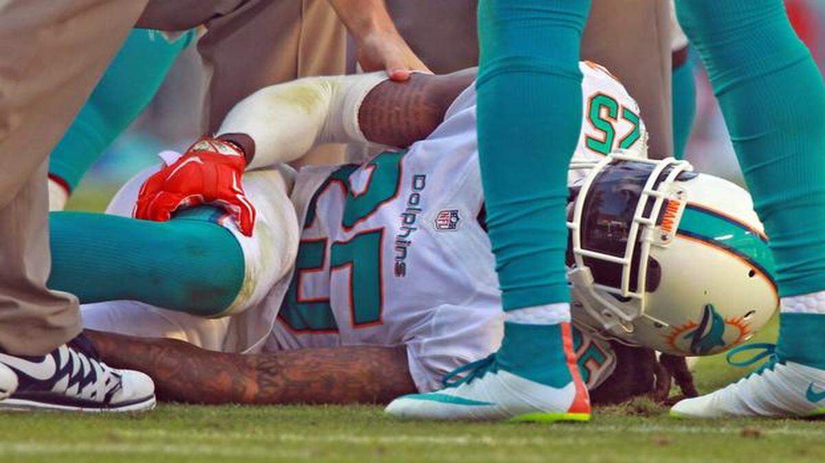 
Miami Dolphins safety Louis Delmas holds his right knee after being injured in the fourth quarter against the Baltimore Ravens at Sun Life Stadium in Miami Gardens, Dec. 7, 2014.
