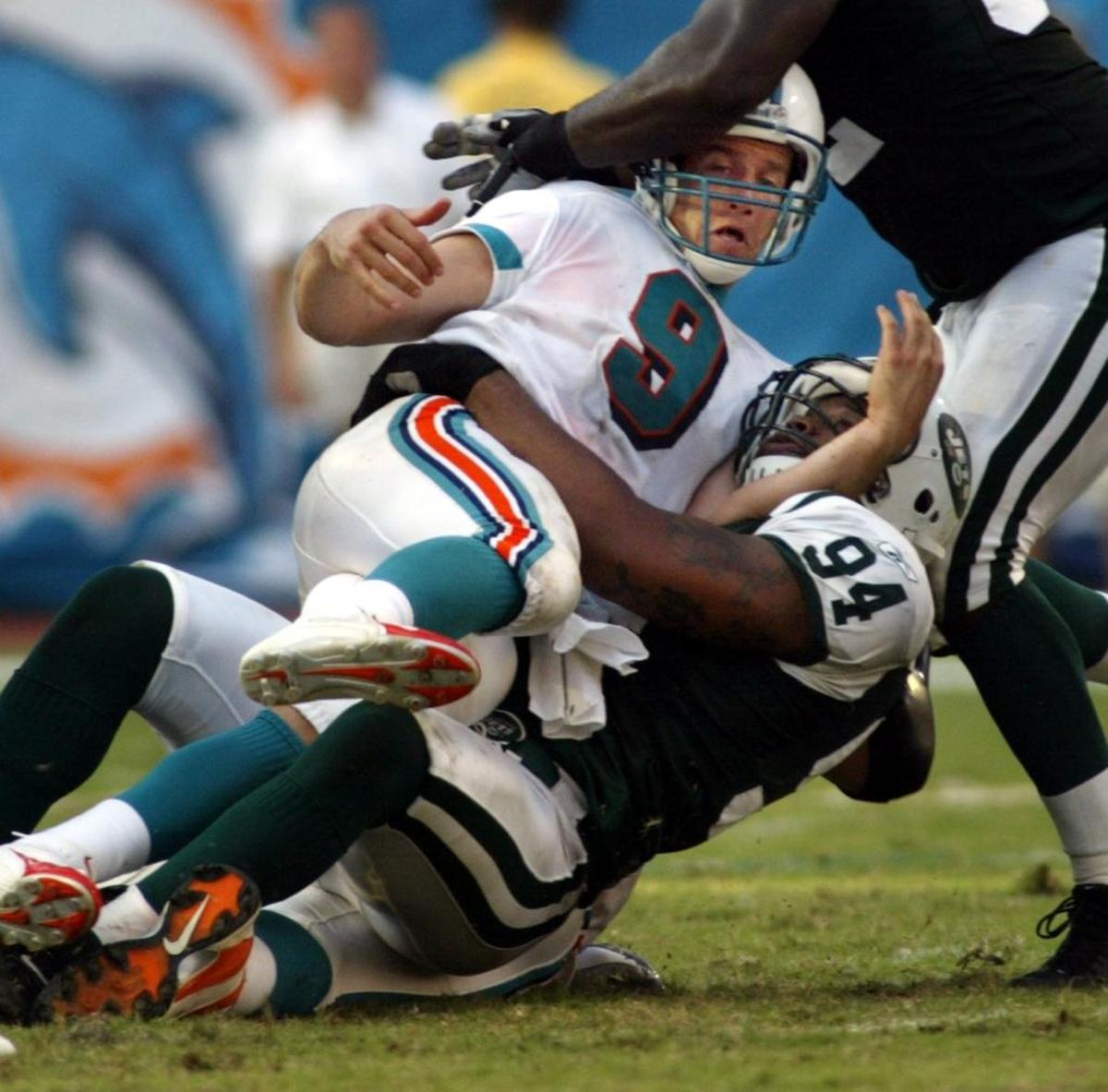 Jay Fiedler is sacked by John Abraham during a Miami Dolphins game against the New York Jets on October 3, 2004.
