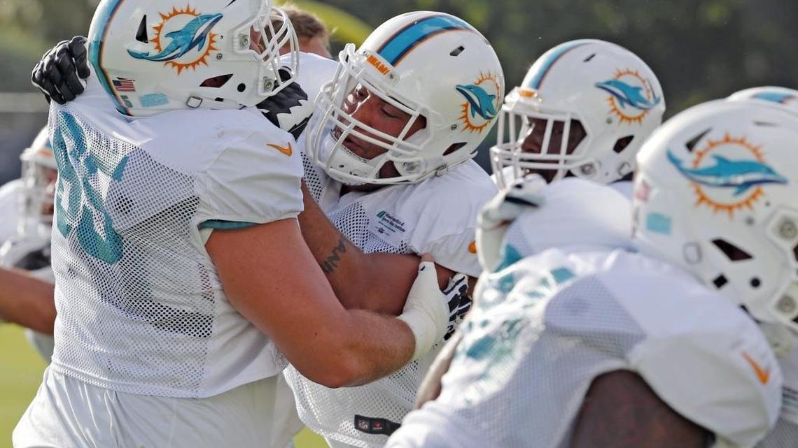 Dolphins guard Anthony Steen 65, holds off the defensive line as the team works out on August 1.