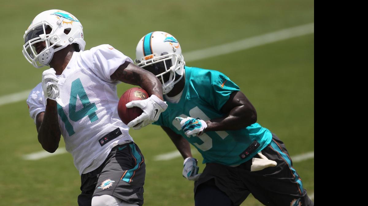 
Miami Dolphins wide receiver Jarvis Landry runs for yardage while being defended by Michael Thomas during practice an Organized Team Activities practice Monday, June 8, 2015 in Davie.
