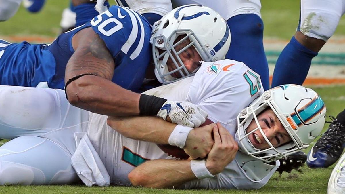 Miami Dolphins quarterback Ryan Tannehill is tackled by Indianapolis Colts’ Jerrell Freeman in the fourth quarter at Sun Life Stadium in Miami Gardens on December 27, 2015.