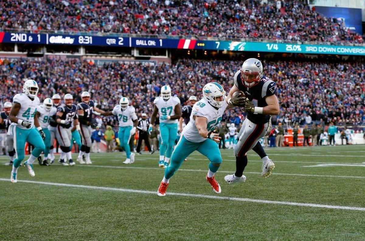 New England Patriots running back Rex Burkhead, right, catches a touchdown pass at the goal line in front of Miami Dolphins linebacker Chase Allen (59) during the first half of the game on Sunday, Nov. 26, 2017, in Foxborough, Massachusetts.