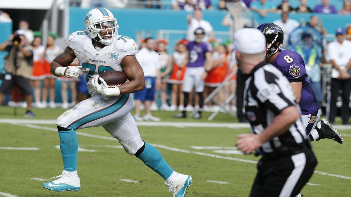 Miami Dolphins defensive end Derrick Shelby (79) scores after deflecting a pass in the second quarter as the Miami Dolphins host the Baltimore Ravens at Sun Life Stadium on Sunday, December 6, 2015
