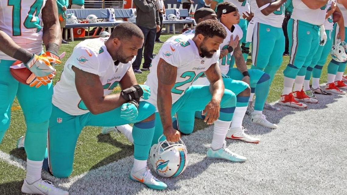 Dolphins players (from left) Jelani Jenkins, Arian Foster, Michael Thomas and Kenny Stills kneel during the national anthem at Sunday’s game in Seattle. Jenkins wrote in a Time essay that he would cease kneeling during the anthem, and Thomas and Stills have said they are undecided whether they would continue to kneel. Foster is the only one of the four who said he would not stop kneeling.