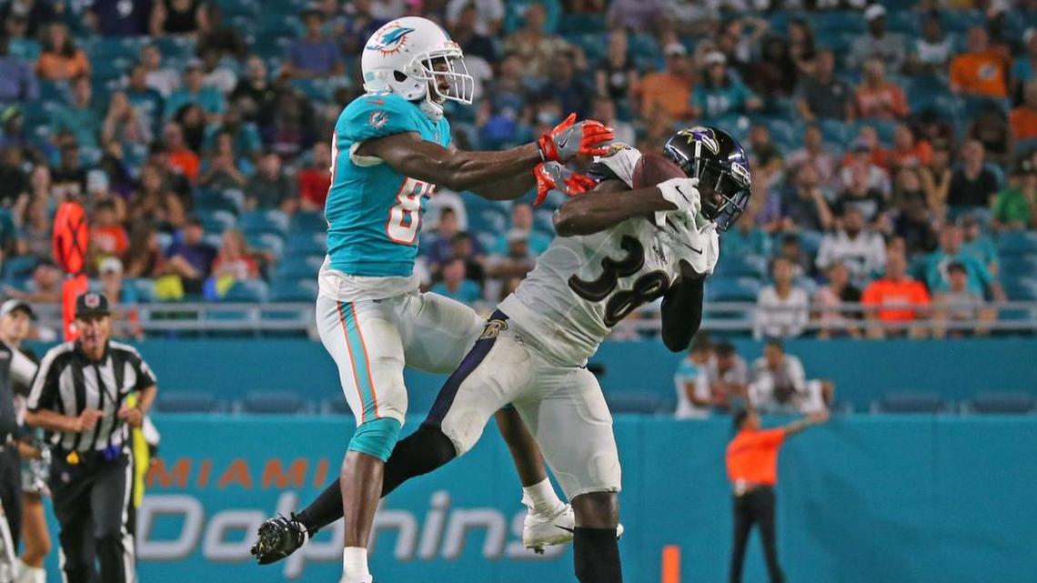 Baltimore Ravens cornerback Stanley Jean-Baptiste intercepts the ball against Miami Dolphins wide receiver Rashawn Scott (87) during Saturday’s preseason game. Scott, a former UM player, had one catch for 38 yards and remains among several receivers battling for a roster spot.