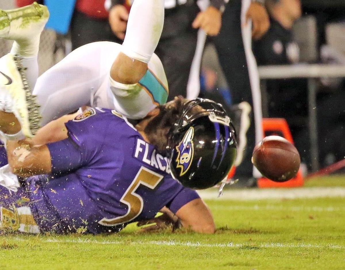 Miami Dolphins Kiko Alonso (47) knocks off and Baltimore Ravens quarterback Joe Flacco (50) helmet in the second quarter at the M&T Bank Stadium in Baltimore, Maryland, Oct. 26, 2017.