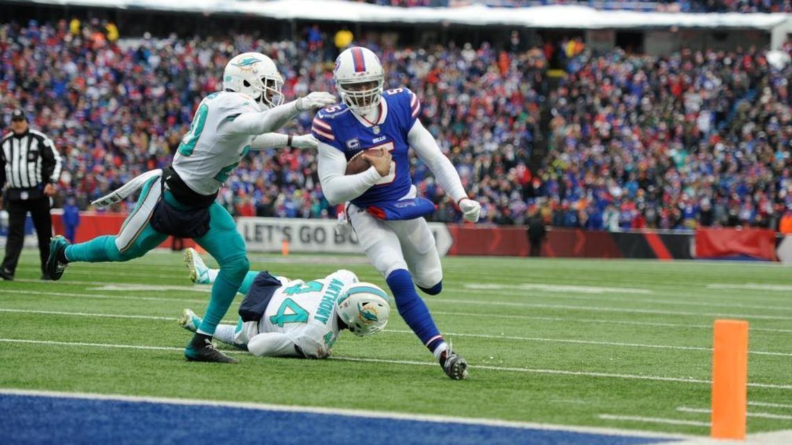 Buffalo Bills quarterback Tyrod Taylor (5) rushes past Miami Dolphins' Stephone Anthony (44) and Reshad Jones (20) for a touchdown during the first half Sunday, Dec. 17, 2017, in Orchard Park, N.Y.