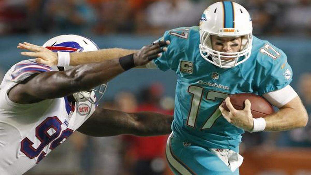 
Quarterback Ryan Tannehill of the Miami Dolphins scrambles for yardage as he is pursued by defensive tackle Kyle Williams of the Buffalo Bills in the second quarter in a game at Sun Life Stadium on November 13, 2014 in Miami Gardens, Florida.
