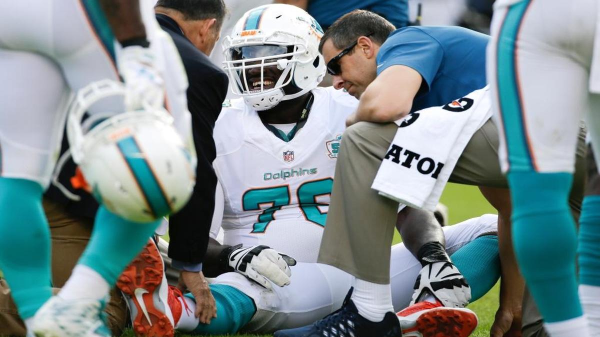 Miami Dolphins offensive tackle Branden Albert is treated on the field after getting hurt during the first half in an NFL football game against the San Diego Chargers Sunday, Dec. 20, 2015, in San Diego.