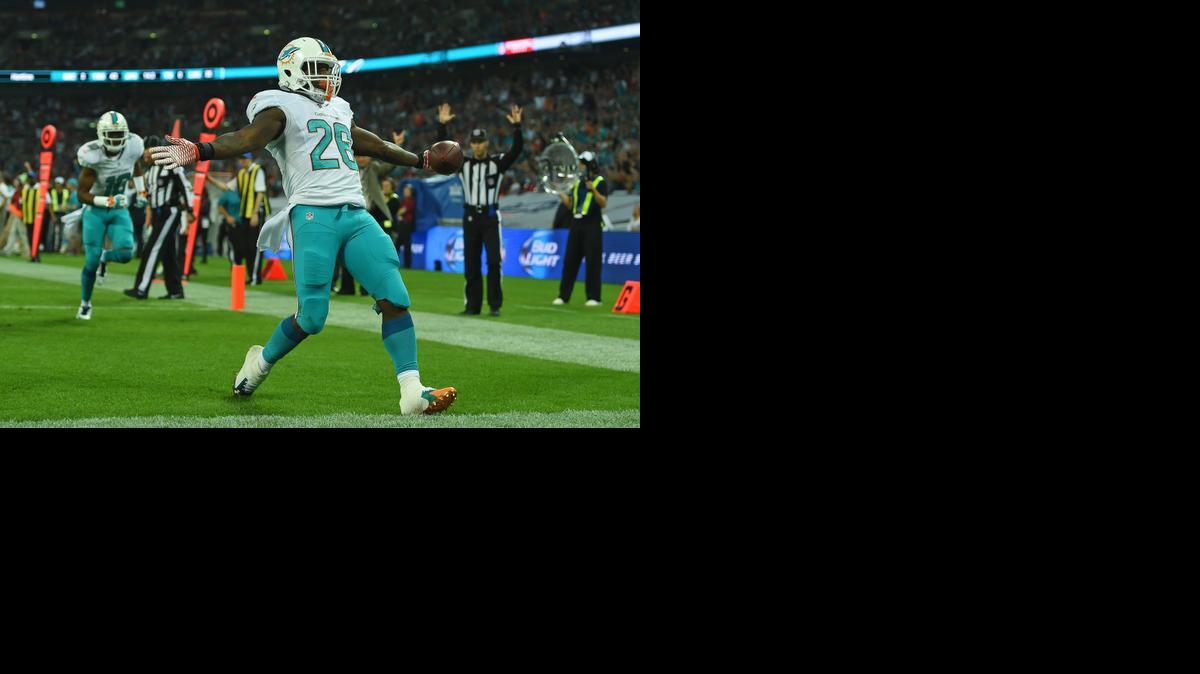 
Miami Dolphins' Lamar Miller celebrates after scoring a touchdown during the NFL football game against Oakland Raiders at Wembley Stadium in London, Sunday, Sept. 28, 2014. 
