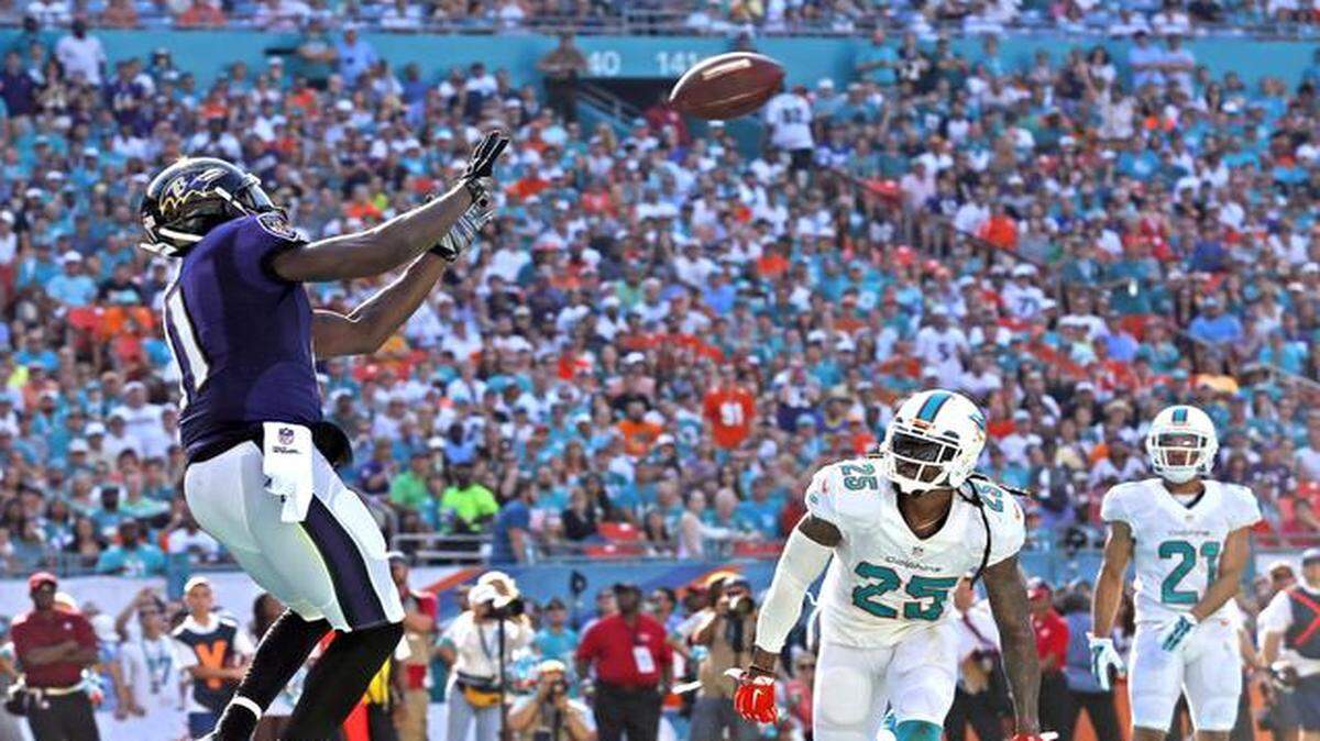 
Miami Dolphins defensive backs Louis Delmas and Brent Grimes watch as Baltimore Ravens wide receiver Kamar Aiken catches a third-quarter touchdown at Sun Life Stadium in Miami Gardens, Dec. 7, 2014.

