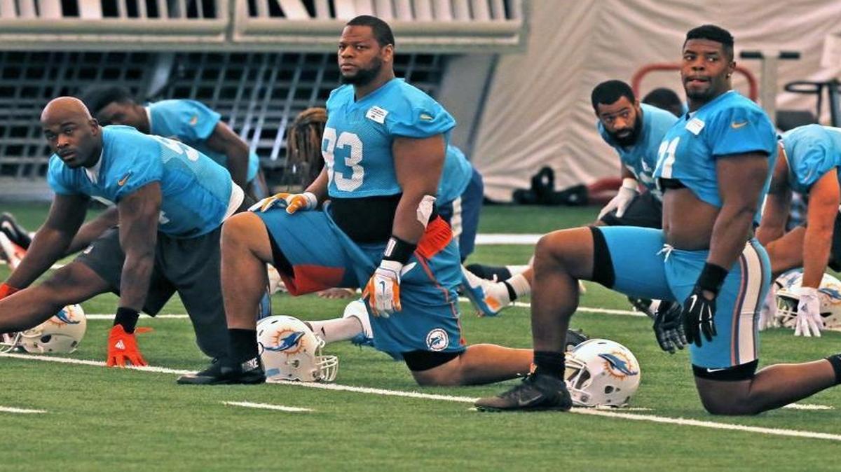 Dolphins Mario Williams, 94, Ndamukong Suh, 93, and Cameron Wake, 91, warm-up at the Miami Dolphins training facility in Davie, Florida, Aug. 23, 2016.