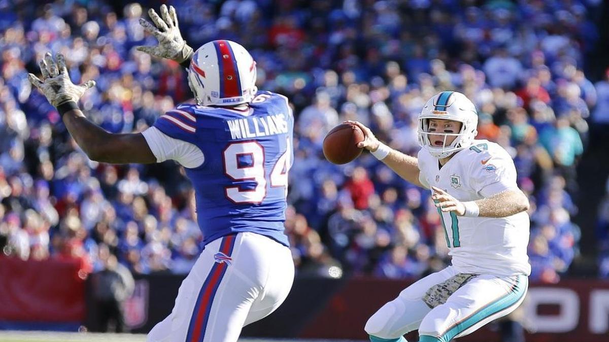 Miami Dolphins quarterback Ryan Tannehill (17) scrambles as Buffalo Bills defensive end Mario Williams defends at Ralph Wilson Stadium, Orchard Park, N.Y. on Sunday, November 8, 2015.