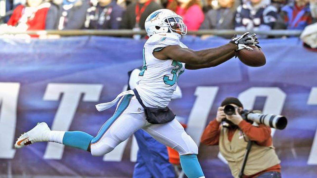 
Dropping the ball: Dolphins running back Damien Williams lets a would-be touchdown reception slip through his hands during Sunday’s loss to New England. With the loss, the Dolphins dropped to 11th in the AFC playoff chase.
