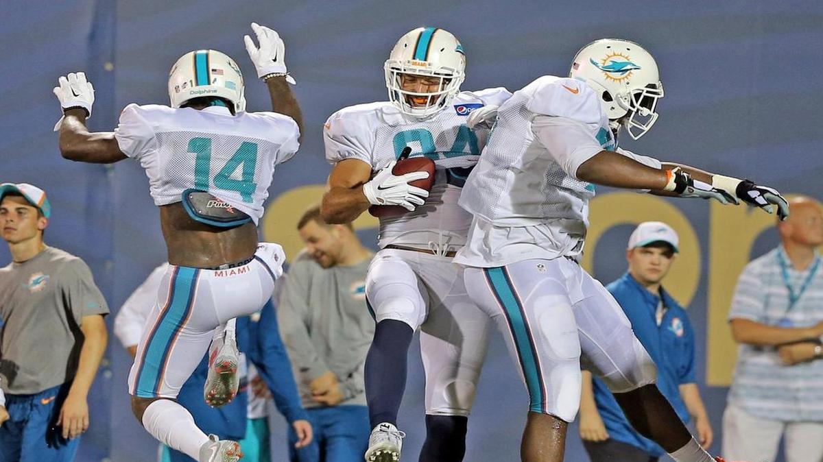 
Miami Dolphins tight end Jordan Cameron (84) celebrates with Jarvis Landry (14) and Ja'Wuan James (70) after catching a touchdown pass during a scrimmage at Ocean Bank Field at FIU on Friday, Aug. 7, 2015.
