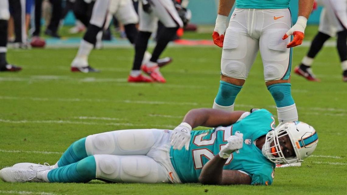 Injured Raekown McMillan (52) lays on the ground waiting for trainers after injuring his knee in his first NFL game.