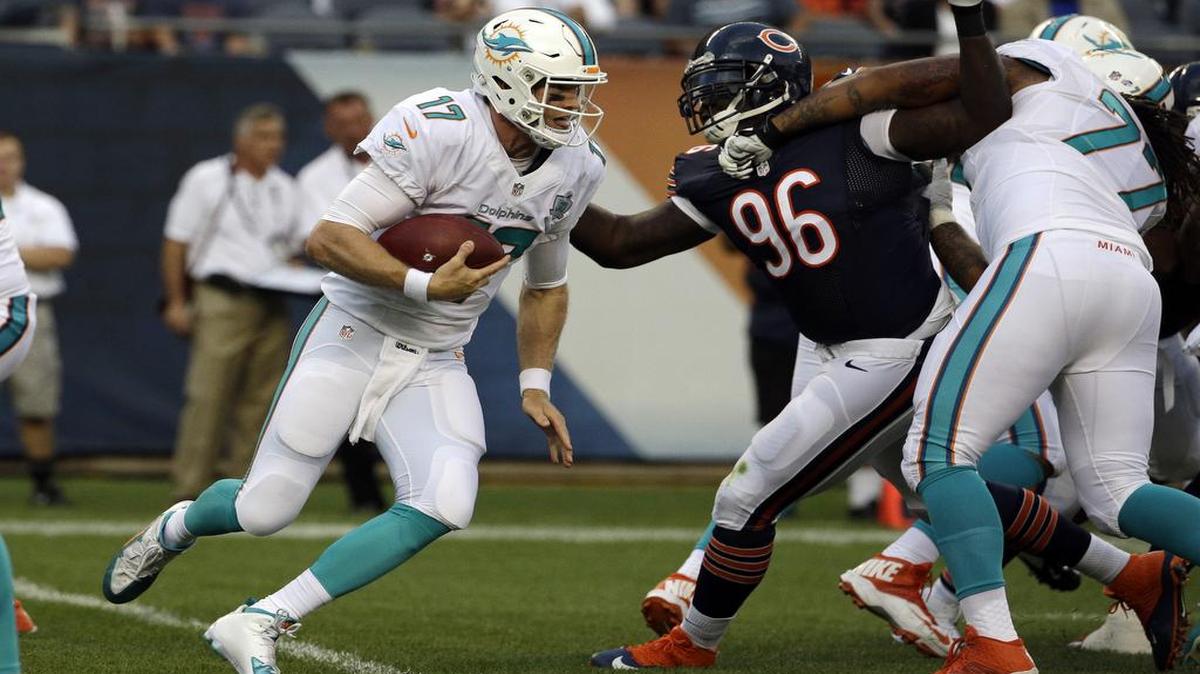 
Miami Dolphins quarterback Ryan Tannehill (17) scrambles past Chicago Bears defensive tackle Jarvis Jenkins (96) to pick up a first down in the first half of an NFL preseason football game in Chicago, Thursday, Aug. 13, 2015. 
