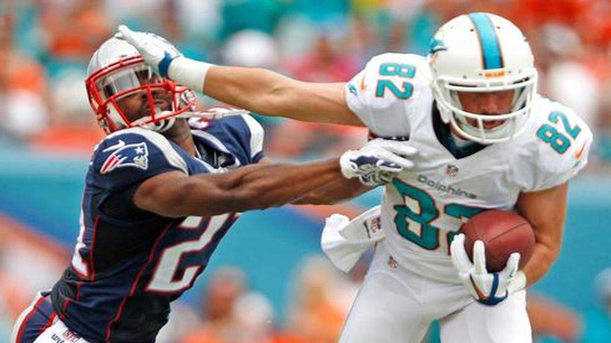 
Miami Dolphins wide receiver Brian Hartline (82) stiff-arms New England Patriots defensive back Malcolm Butler at Sun Life Stadium in Miami Gardens on Sunday, Sept. 7, 2014.
