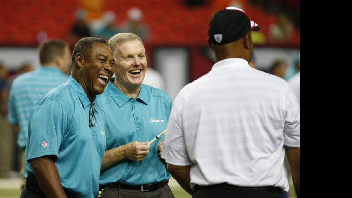 
Former Miami Dolphins player Bob Griese, center, speaks with others before the first half of an NFL football game against the Atlanta Falcons, Friday, Aug. 8, 2014, in Atlanta. 
