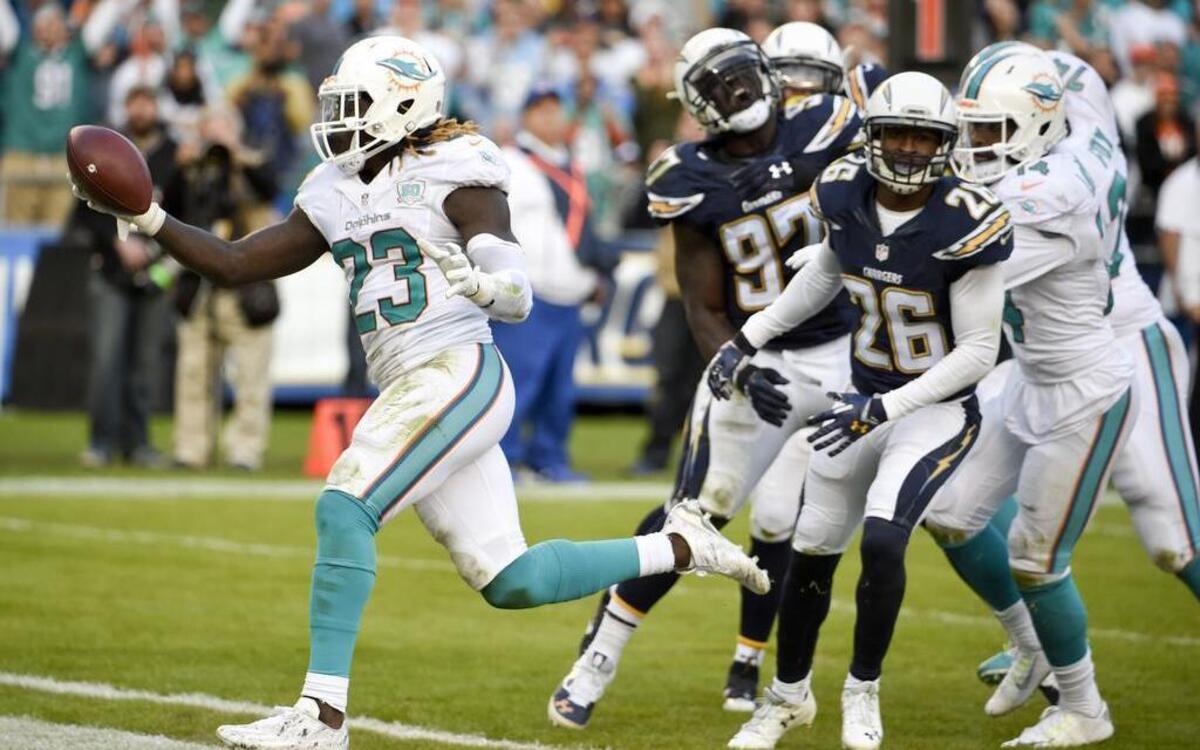 Miami Dolphins strong safety Reshad Jones runs around San Diego Chargers linebacker Nick Dzubnar after an inception during the first half in an NFL football game Sunday, Dec. 20, 2015, in San Diego.