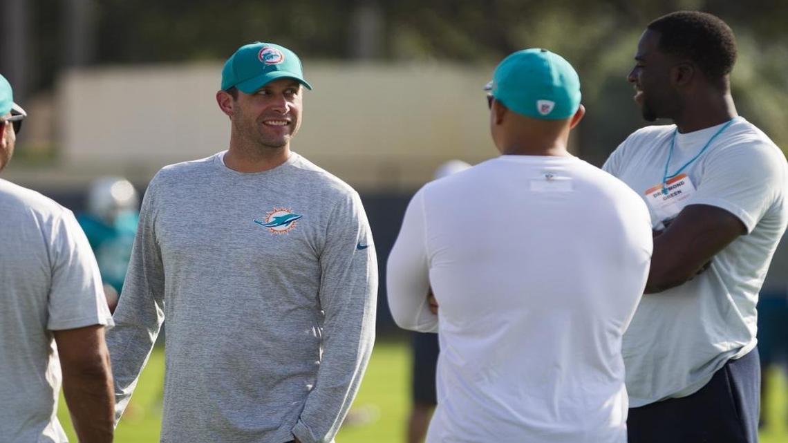 Dolphins coach Adam Gase chats up Golden State Warriors forward Draymond Green during training camp Sunday.