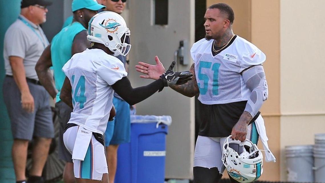 The Miami Dolphins’ Jarvis Landry (14) greets Mike Pouncey (51) on the first day of 2017 training camp.