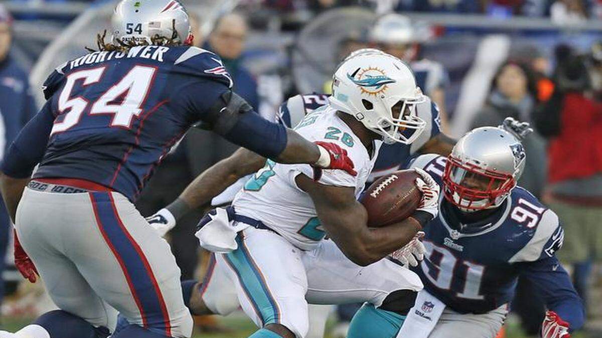 
Miami Dolphins running back Lamar Miller (26) is shut down by Patriot defenders in the fourth quarter as the New England Patriots host the Miami Dolphins at Gillette Stadium on Sunday, Dec. 14, 2014
