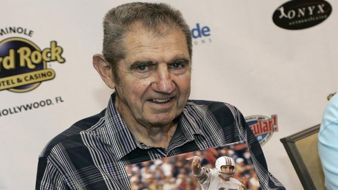 Earl Morrall with a 1972 photo of himself playing quarterback for the Miami Dolphins during an event on September 4, 2011, at Seminole Hard Rock & Casino in Fort Lauderdale, Fla. Morrall helped save the team's perfect season, stepping in at quarterback after starter Bob Griese was injured. Morrall died on Friday, April 25, 2014, at 79.
