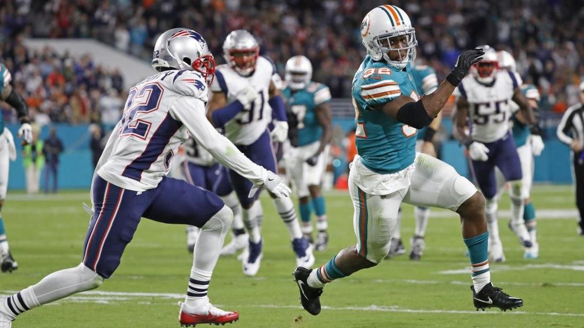 Miami Dolphins running back Kenyan Drake (32) runs towards the goal line as New England Patriots free safety Devin McCourty (32) gives chase in the second quarter as the Miami Dolphins host the New England Patriots at hard Rock Stadium on Mon., Dec. 11, 2017.