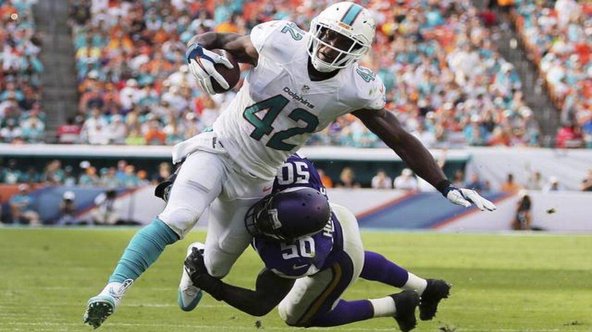
Tight end Charles Clay #42 of the Miami Dolphins is brought down by outside linebacker Gerald Hodges #50 of the Minnesota Vikings in the third quarter during a game at Sun Life Stadium on December 21, 2014 in Miami Gardens, Florida. 
