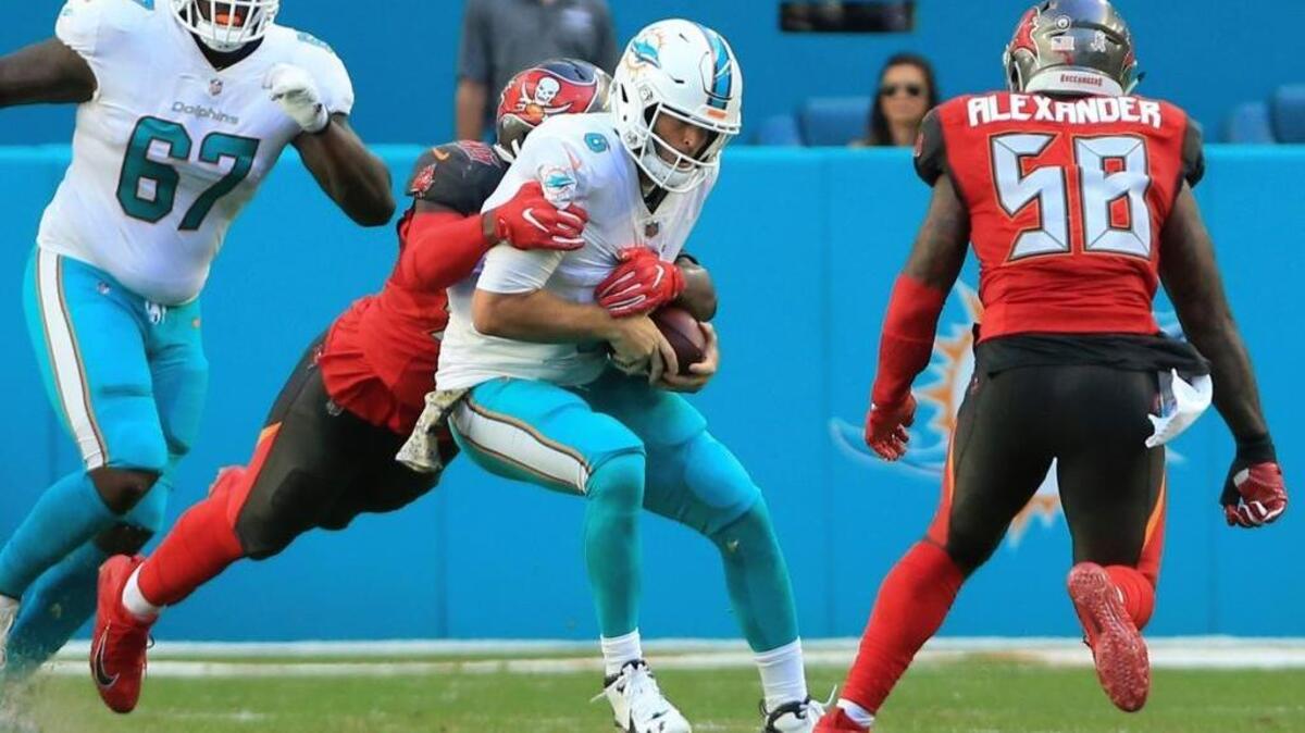 Miami Dolphins quarterback Jay Cutler (6) is taken down by Tampa Bay Buccaneers defensive end Ryan Russell (95) late in the second quarter of an NFL football game Sunday, Nov. 19, 2017 in Miami. Cutler left the game with a head injury.