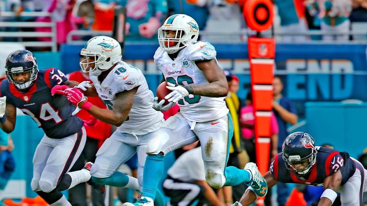 Miami Dolphins Lamar Miller pulls away from Houston Texans Rahim Moore as Miller scores a touchdown in the second quarter at Sun Life Stadium in Miami Gardens, Florida, October 25, 2015.