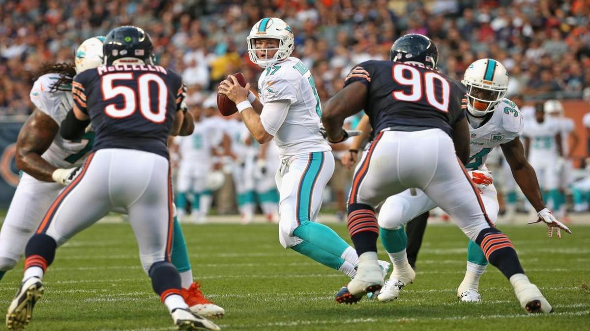 
Ryan Tannehill #17 of the Miami Dolphins looks for a receiver as Shea McClellin #50 and Jeremiah Ratliff #90 of the Chicago Bears rush during a preseason game at Soldier Field on August 13, 2015 in Chicago, Illinois. 
