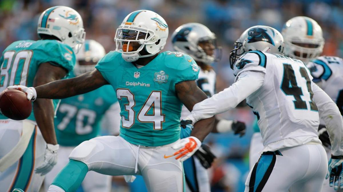 
Miami Dolphins' Damien Williams (34) runs past Carolina Panthers' Roman Harper (41) for a touchdown during the first half of an NFL preseason football game in Charlotte, N.C., Saturday, Aug. 22, 2015. 
