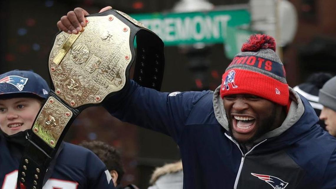New England Patriots linebacker Barkevious Mingo hoists a wrestling belt during the Patriots’ victory parade.