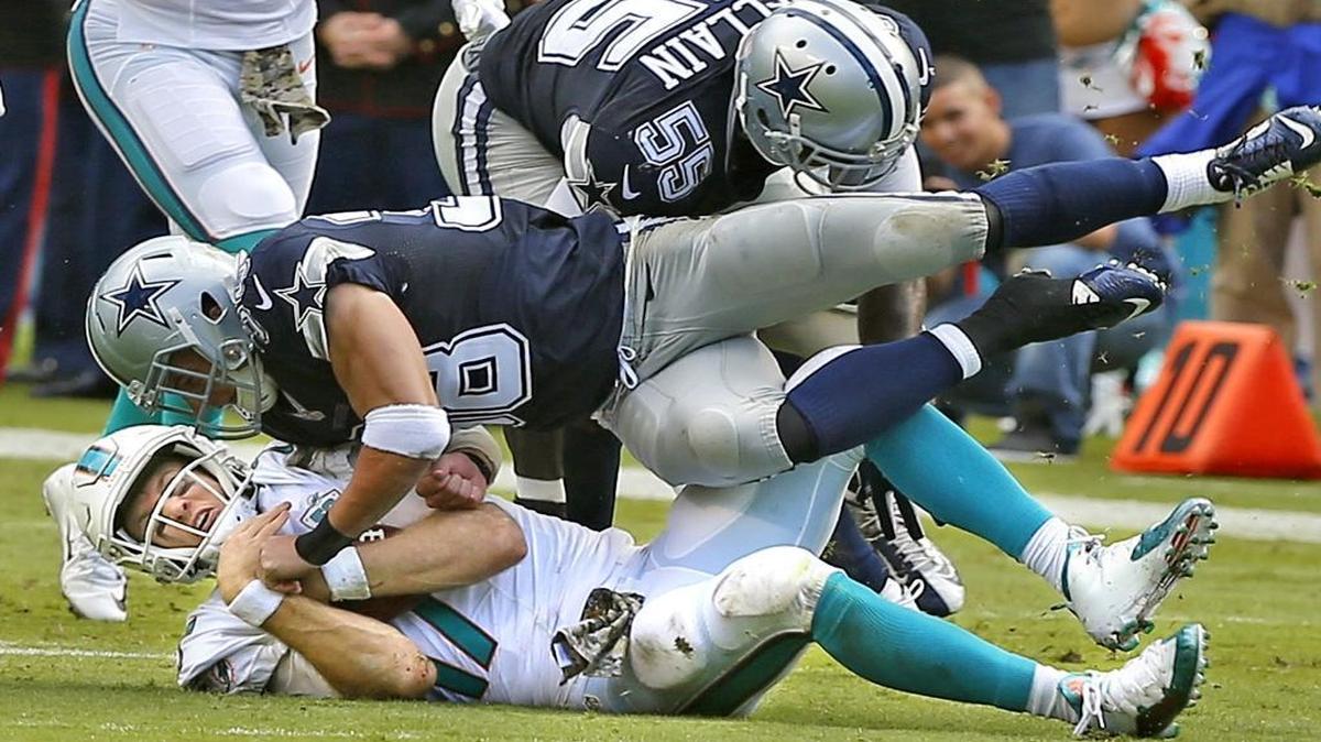 Miami Dolphins quarterback Ryan Tannehill gets tackled by Dallas Cowboys Jeff Heath as Tannehill ran for a short gain in the second quarter at Sun Life Stadium in Miami Gardens, Florida, November 22, 2015.
