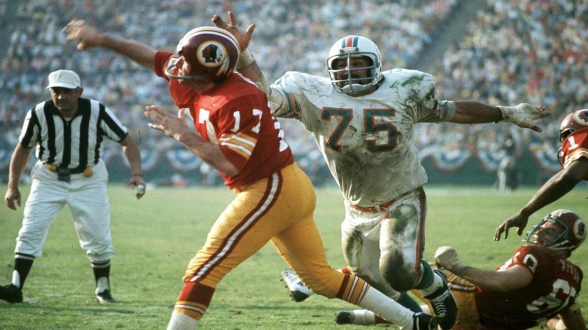 From the archives: Two Redskin blockers, right, cant keep Miami Dolphins Manny Fernandez (75) from pressuring Redskins QB Billy Kilmer in Superbowl VII on January 4, 1973.