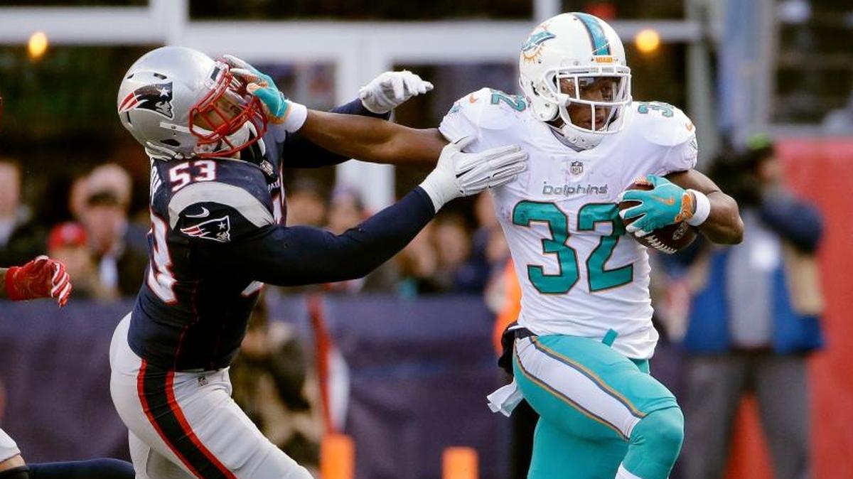 Miami Dolphins running back Kenyan Drake (32) gives a stiff arm to New England Patriots linebacker Kyle Van Noy (53) during the first half of an NFL football game, Sun., Nov. 26, 2017, in Foxborough, Mass.
