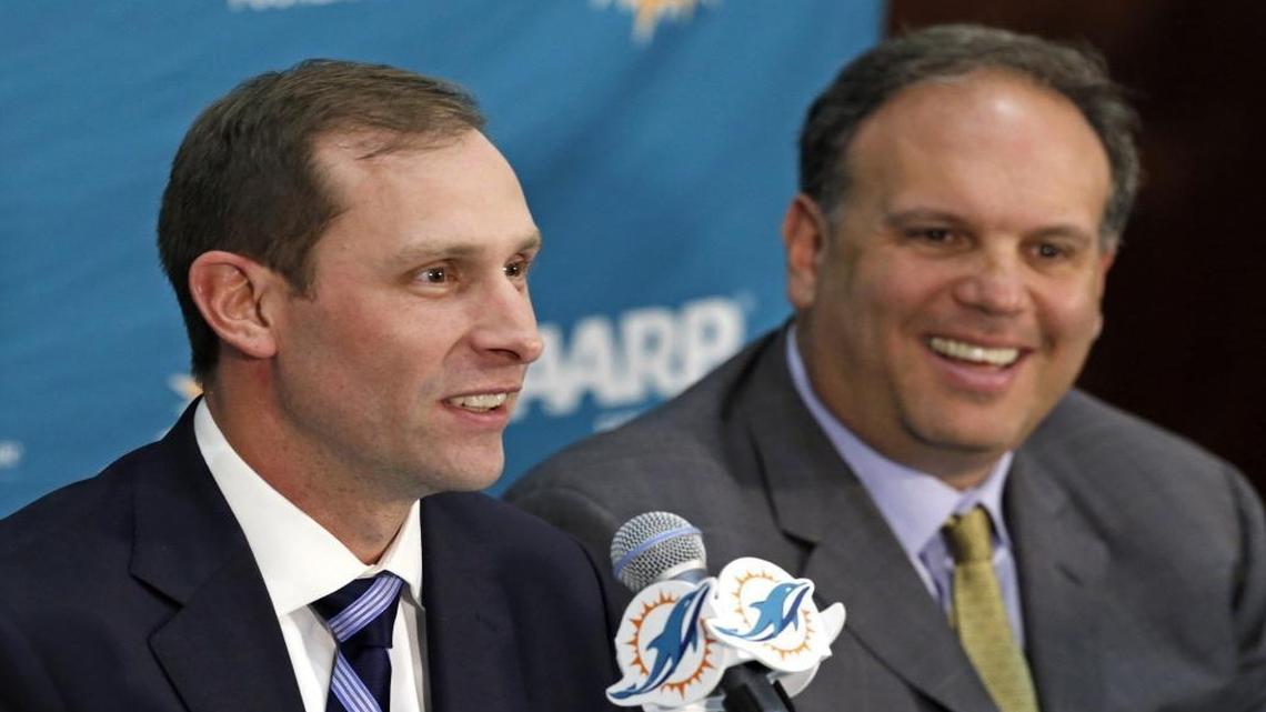 Miami Dolphins coach Adam Gase, left, and Mike Tannenbaum will pare the Dolphins’ roster from 75 to 53 by 4 p.m. Saturday.
