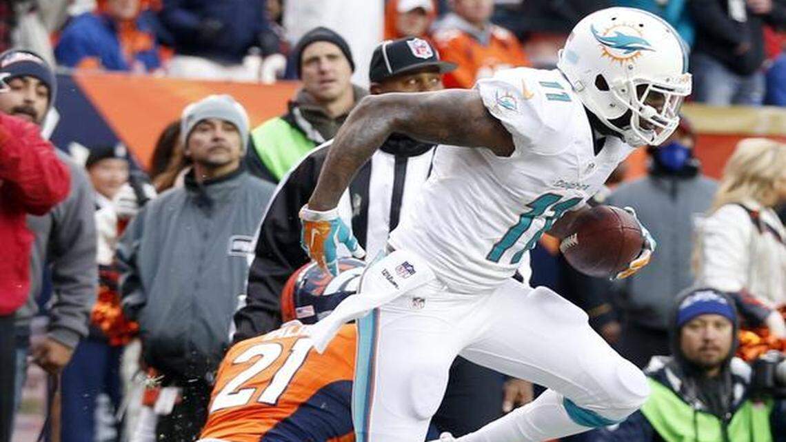 
Miami Dolphins receiver Mike Wallace leaps after scoring a touchdown late in the second quarter as they play Denver Broncos at Sports Authority Field at Mile High in Denver, Colorado, Nov. 23, 2014.
