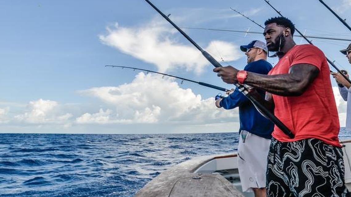 Dolphins tackle Jason Fox, rear, and safety Reshad Jones, front, during the 2015 Fins Weekend Fishing Tournament.