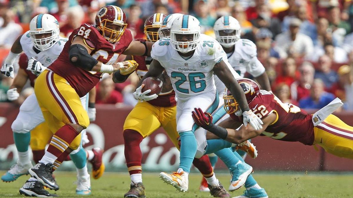 
Dolphins running back Lamar Miller (26) breaks tackles for a first down during the third quarter against the Redskins in last Sunday’s game. Miller averaged a modest 4.1 yards per rush in the game, but he got only 13 carries. 

