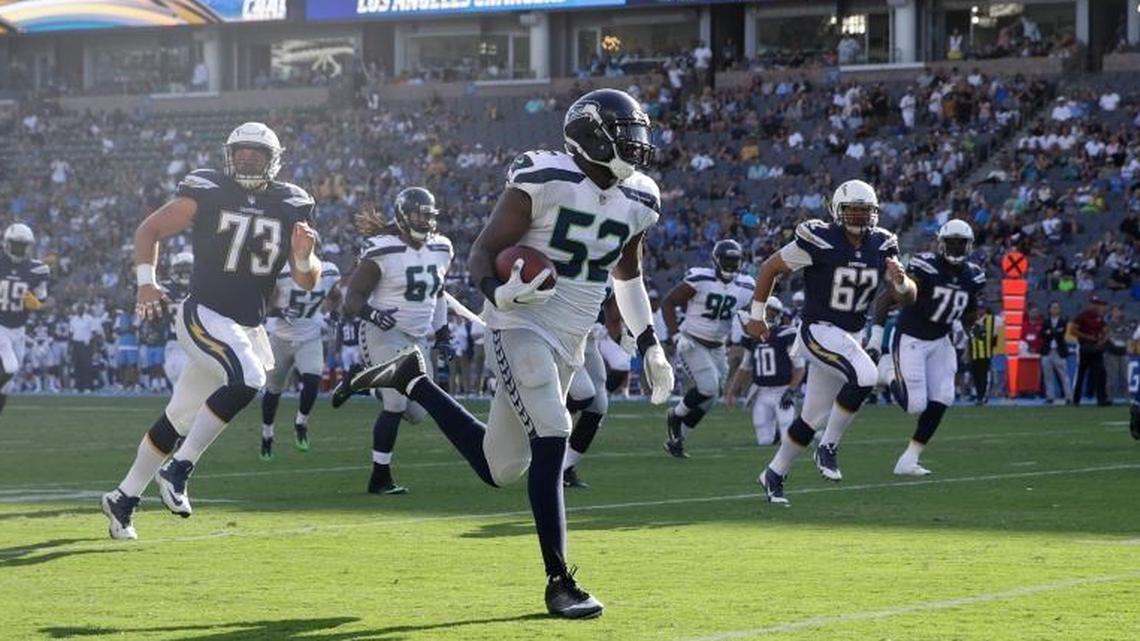Seattle Seahawks linebacker Terence Garvin (52) runs back an interception for a touchdown during the first half of an NFL preseason football game against the Los Angeles Chargers on Sunday, Aug. 13, 2017, in Carson, Calif.