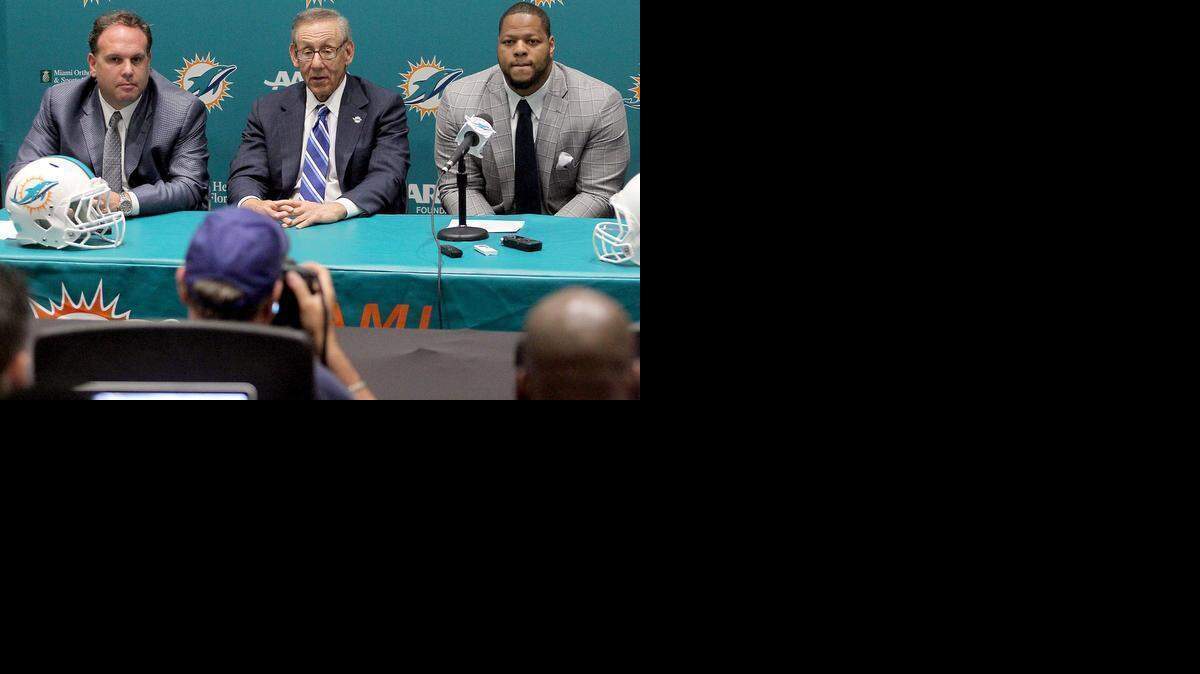 Miami Dolphins Executive Vice President of Football Operations Mike Tannenbaum, left, and owner Stephen Ross introduce Ndamukong Suh at a press conference Wednesday, March 11, 2015.